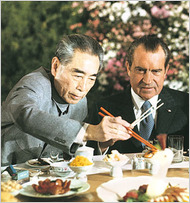 Premier Zhou Enlai teaches President Nixon how use chopsticks (1972).