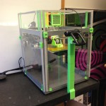 shows Solidoodle 3 printer with plexiglass enclosure with webcam - all printed add-ons used fluorescent green plastic.
