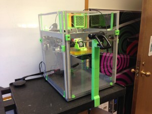 shows Solidoodle 3 printer with plexiglass enclosure with webcam - all printed add-ons used fluorescent green plastic.